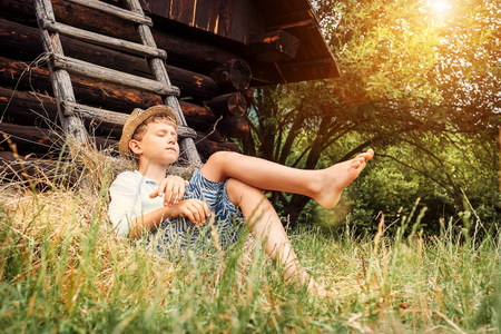 Little lazy boy sleeps under old hayloft in gardenの写真素材