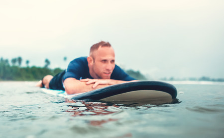 Resting surfer man on the board