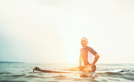 Man surfer sits on surf board in the water and  waits wavesの写真素材