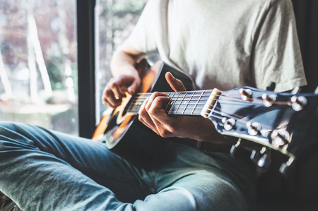 Man hands playing on guitar - close up imageの写真素材