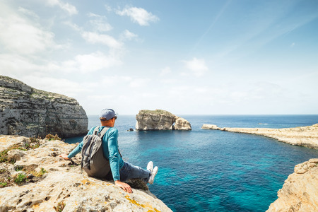 Coastal walker relax on rocky seasideの写真素材