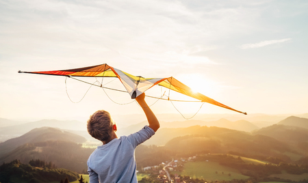 Boy takes a kite over his head. Dreams about flyingの写真素材