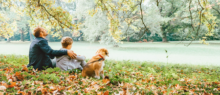 Father with son walk with beagle dog and enjoy warm autumn dayの写真素材