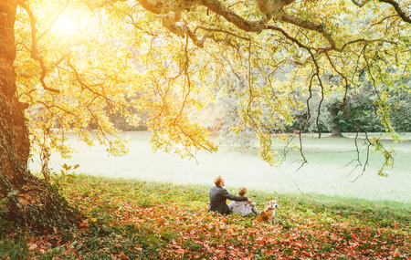 Father with son walk with beagle dog and enjoy warm autumn dayの写真素材