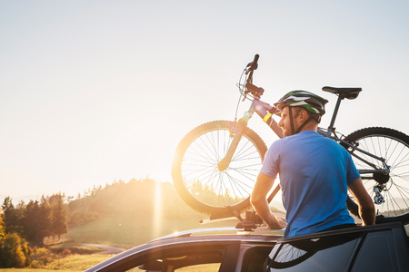 Man take his bicycle from car roof. Mountain biking conceptの写真素材