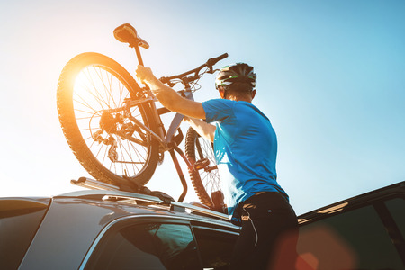 Mountain biker man take of his bike fron the car roofの写真素材