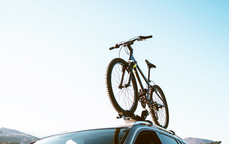 Mountain Bicycle fixed with Roof Mounted Bike Carriers instaled on white Auto roof travel concept imageの写真素材