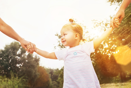 Cute little girl take hands with her relatives peopleの写真素材