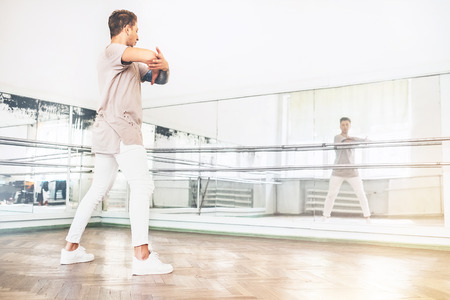 Young teen dancer exercise the dance element in front of the mirror portrait in the hallの写真素材