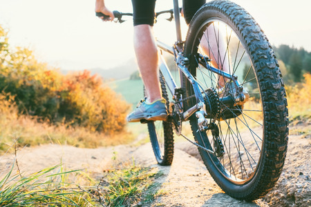 Mountain biker ride down from hill. Close up wheel imageの写真素材