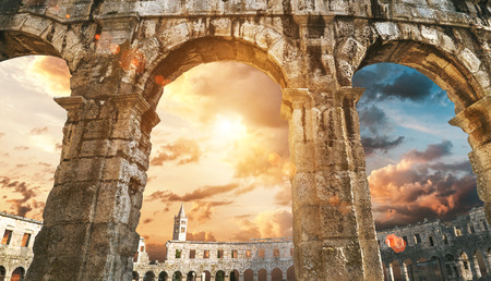 Pula amphitheater arches with sunset skyの写真素材