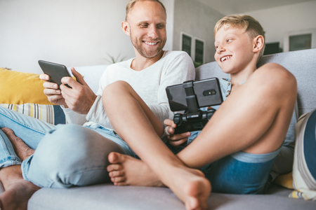 PC games fans Father and son play together with electronic devicesの写真素材