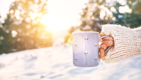 Woman take in hand cup of hot drink. Mug close up shoot.の写真素材