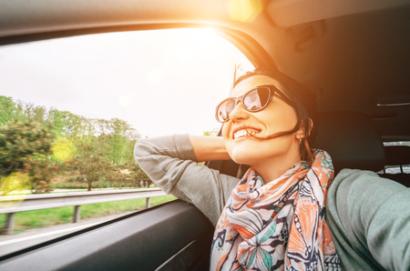 Woman enjoy with view from car window when traveling by autoの写真素材