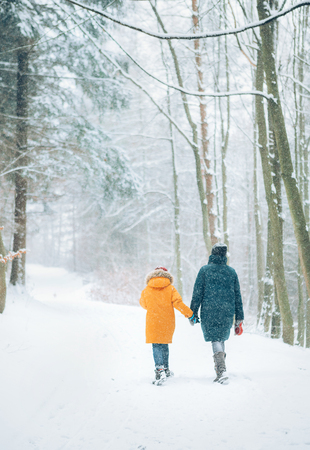 Mother and son walking in snowy forest. Mother and son relatives concept image.の写真素材