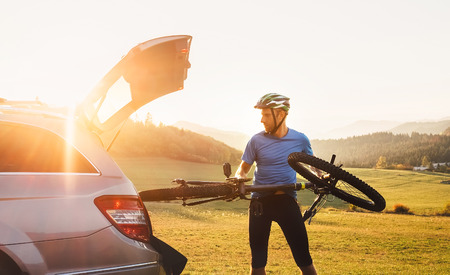Man put his bicycle in the trunk of a carの写真素材
