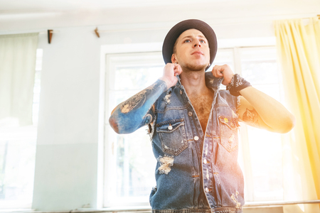 Dancer man in denim jacket posing in dance hallの写真素材