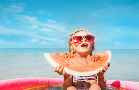 Little girl with big watermelon segment funny seside portraitの写真素材
