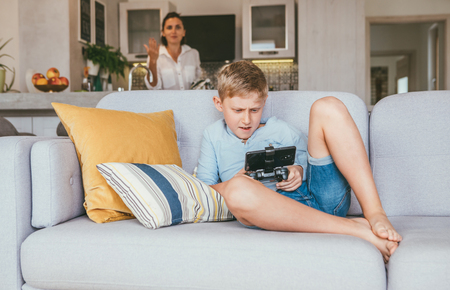 Boy plays with electronic device but his mother not happy with thisの写真素材