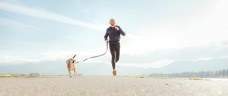 Running man with his dog . Active healthy lifestyle concept image.の写真素材