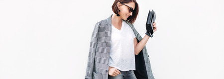 Woman dressed gray and white casual outfit with checkered jacketの写真素材