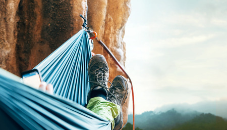 Climber resting in hammock on the vertical cliff wallの写真素材