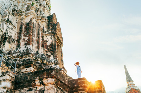 Woman traveler tiny figurine on huge ancient Wat Ratburana tample in Ayutthaya Historical Park, Thailandの写真素材