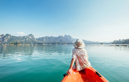 Little boy floating on kayak on Cheow Lan Lake, Khao Sok national park, Thailandの写真素材