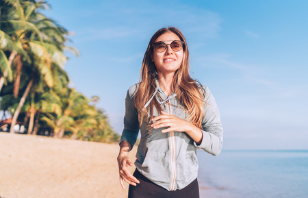 Fashionable young longhaired woman have morning jogging on the seaside beachの写真素材