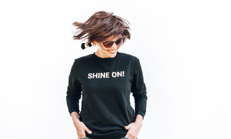 Free feeling happy smiling woman posing in black sweatshirt with positive print Shine Onの写真素材
