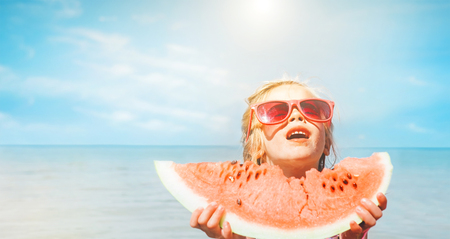 Little girl with big watermelon segment funny seside portraitの写真素材