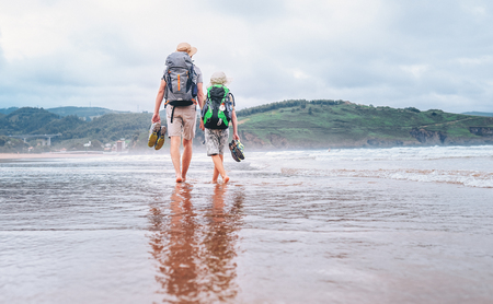 Father with son walk barefoot on the sand ocean beachの写真素材