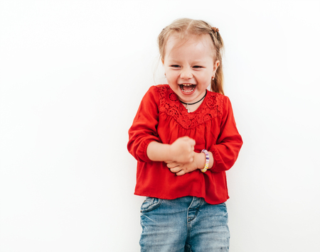 Happy emotions of Little girl dressed red blouse on the white background.の写真素材