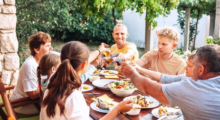 Big family have a dinner on garden terraceの写真素材