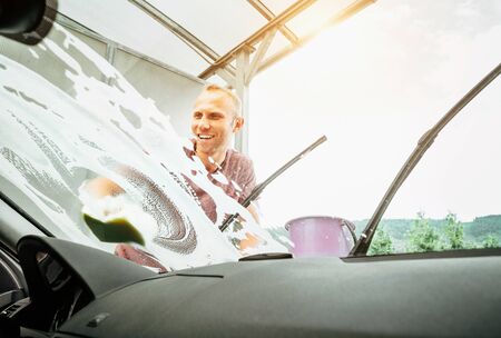 Inside the car camera view of Man washes his car windshield windowの写真素材