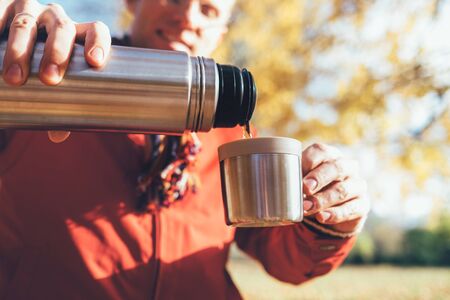 Young male hands pouring a hot tea into cupの写真素材