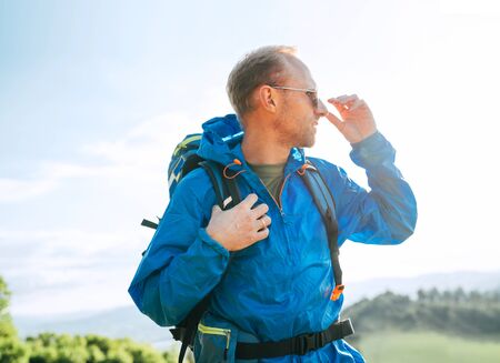 Backpacker man lifestyle side portrait enjoying mountain landscape.の写真素材