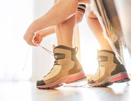 New trekking boots tying a laces moment in the morning new day sunlightの写真素材