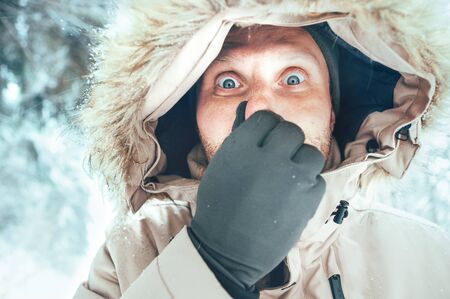 Funny man dressed in Warm Hooded Casual Parka Jacket Outerwear with frozen nose winter portrait. Health on winter time concept image.の写真素材
