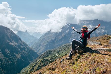 Young hiker backpacker female rising her armsの写真素材