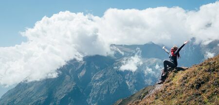 Young hiker backpacker female rising her armsの写真素材