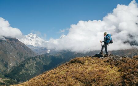 Young hiker backpacker man using trekking poles enjoying the Nuptse 7861m mountain during high altitude Acclimatization walk.の写真素材