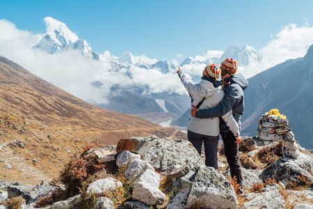 Couple having a rest on Everest Base Camp trekking route near Dughla 4620m.の素材 [FY310134361267]