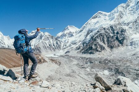 Young hiker backpacker female taking brake in hike walking enjoying Khumbu Glacier.の写真素材