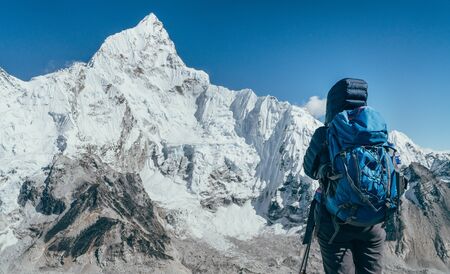 Young hiker backpacker female taking brake in hike walking enjoying Khumbu Glacier.の写真素材