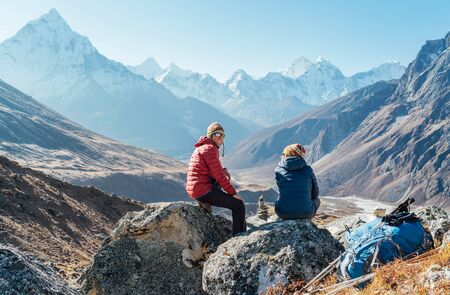 Cute Couple resting on the Everest Base Camp trekking route near Dughla 4620m.の写真素材