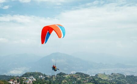 Paragliding with instructor using colorful paraglider over Pokhara town, Nepal.の写真素材