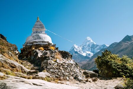 Buddhist Stupa - architectural and religious structure with Ama Dablam 6814m peak covered with snow and ice.の写真素材