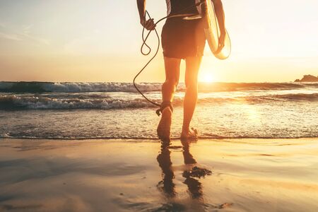 Man surfer runing in ocean with surfboard.  Close up legs image at Weligama beach,Sri Lankaの写真素材