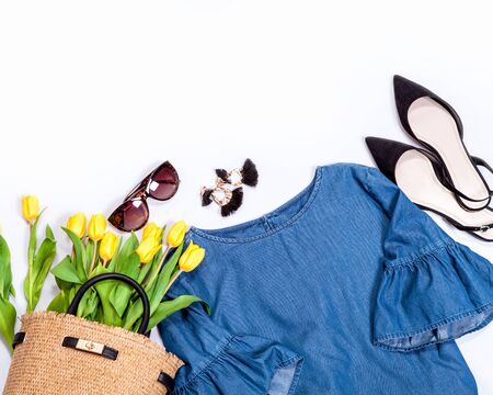 Spring summer basic denim casual city trend outfit set for woman: jeans blouse with wide sleaves, shoes, earrings, sunglasses and handbag full of yellow tulips.の写真素材